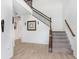 Bright foyer with hardwood floors, elegant staircase, and decorative accents at 3027 Marine Grass Dr, Wimauma, FL 33598