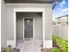 Inviting front entrance with a decorative wreath, stylish door, and charming pathway at 3027 Marine Grass Dr, Wimauma, FL 33598