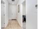 Bright hallway with hardwood flooring leading to the bedroom and front door at 3027 Marine Grass Dr, Wimauma, FL 33598