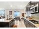 Modern kitchen with dark wood cabinetry and granite countertops, open to the dining area at 3027 Marine Grass Dr, Wimauma, FL 33598