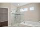 Bright bathroom featuring glass shower, soaking tub, and linen closet at 30653 Parrot Reef Ct, Wesley Chapel, FL 33545