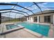 View of pool and spa from rear patio with screened-in enclosure at 30653 Parrot Reef Ct, Wesley Chapel, FL 33545