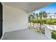 A covered balcony with white railings offers scenic views of lush palm trees and the neighborhood at 3201 S Manhattan Ave, Tampa, FL 33629