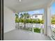 Balcony view of tropical trees, a white fence, and a house at 3201 S Manhattan Ave, Tampa, FL 33629