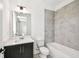A bathroom featuring gray tiled walls over the tub, dark vanity with white countertop, and a large mirror at 3201 S Manhattan Ave, Tampa, FL 33629