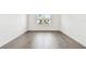 An empty bedroom shows light gray wood floors and natural light from the window at 3201 S Manhattan Ave, Tampa, FL 33629