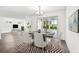 Open-concept dining space next to a living room with modern furniture and access to an outdoor balcony at 3201 S Manhattan Ave, Tampa, FL 33629