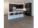 Modern kitchen boasts dark cabinetry, stainless steel appliances, and a large center island with bar seating at 3201 S Manhattan Ave, Tampa, FL 33629
