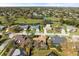 Wide angle aerial showing neighborhood with mature trees, a pond and a golf course under a bright sunny sky at 3285 Sandy Ridge Dr, Clearwater, FL 33761