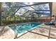 Backyard featuring a screened-in pool with a lounge chair and plenty of greenery at 3285 Sandy Ridge Dr, Clearwater, FL 33761