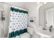 Bathroom with white fixtures, patterned shower curtain, and matching towel at 3422 Cypress Landing Dr, Valrico, FL 33596