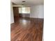 A bright living room with wood-look laminate floors and a large window for natural light at 3606 Richboro Dr, Holiday, FL 34691