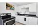 Well-lit kitchen with stainless steel appliances, black counters and white cabinets at 3711 1St S Ave, St Petersburg, FL 33711