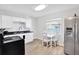 A compact kitchen features white cabinets, stainless appliances, and a small breakfast table at 3711 1St S Ave, St Petersburg, FL 33711