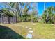 Lush backyard featuring a shed, stepping stones, and mature trees at 3820 E Lakeshore Dr, Tampa, FL 33604