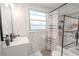 A white bathroom features a shower with gray and white tiling at 3820 E Lakeshore Dr, Tampa, FL 33604