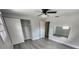 A bedroom features a built-in closet, a ceiling fan, and wood-look floors at 3820 E Lakeshore Dr, Tampa, FL 33604