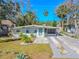 Charming single-story home with a well-manicured lawn, minimalist landscaping, and a modern exterior at 3820 E Lakeshore Dr, Tampa, FL 33604