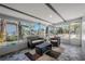 Sun room with windows all around, modern ceiling beams and wicker furniture at 3820 E Lakeshore Dr, Tampa, FL 33604