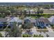 Scenic aerial view of a community, showcasing houses with lawns and nearby road, set against a backdrop of trees at 410 Manns Harbor Dr, Apollo Beach, FL 33572