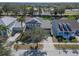High-angle shot of home's street appeal, surrounded by manicured lawns, mature trees, and neighboring houses in a suburban setting at 410 Manns Harbor Dr, Apollo Beach, FL 33572