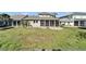 Backyard view showcasing the lawn, screened patio, and fire pit at 410 Manns Harbor Dr, Apollo Beach, FL 33572