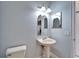 Powder room with a pedestal sink, decorative lighting, and a toilet at 410 Manns Harbor Dr, Apollo Beach, FL 33572