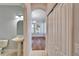 Bathroom and hallway with a pedestal sink and closet, leading into a dining room with hardwood floors at 410 Manns Harbor Dr, Apollo Beach, FL 33572