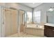 Bright bathroom featuring a glass-enclosed shower and soaking tub under natural light from multiple windows at 410 Manns Harbor Dr, Apollo Beach, FL 33572