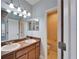 Bathroom with double sinks, granite countertops, framed mirror and vanity lighting at 410 Manns Harbor Dr, Apollo Beach, FL 33572