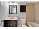 Bathroom featuring dark vanity, marble countertop, and tile surrounding tub at 410 Manns Harbor Dr, Apollo Beach, FL 33572