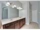 Bathroom featuring a double sink vanity with dark wood cabinets and bright lighting fixtures above a large mirror at 410 Manns Harbor Dr, Apollo Beach, FL 33572