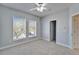 Bedroom with neutral walls, carpet, a ceiling fan, and natural light from double windows and open closet at 410 Manns Harbor Dr, Apollo Beach, FL 33572