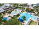Aerial view of a large community pool complex with multiple pools, palm trees, lounge chairs, and recreational areas at 410 Manns Harbor Dr, Apollo Beach, FL 33572