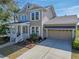 Tan two-story home with manicured garden, white trim and attached garage at 410 Manns Harbor Dr, Apollo Beach, FL 33572