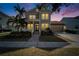 Charming two-story home at dusk, featuring a manicured lawn, and two car garage at 410 Manns Harbor Dr, Apollo Beach, FL 33572