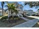 Charming two-story home featuring a landscaped front yard and inviting porch with white railings and a brick walkway at 410 Manns Harbor Dr, Apollo Beach, FL 33572