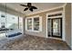 Charming front porch with a porch swing, brick flooring, and a ceiling fan at 410 Manns Harbor Dr, Apollo Beach, FL 33572