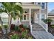 Inviting front porch with decorative columns, stone steps, and lush landscaping at 410 Manns Harbor Dr, Apollo Beach, FL 33572