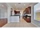 Open kitchen with stainless steel appliances, dark wood cabinetry, and modern tile flooring at 410 Manns Harbor Dr, Apollo Beach, FL 33572