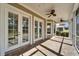 Covered patio with brick flooring, ceiling fans, and multiple doors leading inside at 410 Manns Harbor Dr, Apollo Beach, FL 33572
