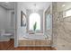 Bright bathroom with large soaking tub, chandelier, and glass enclosed shower at 5204 Avenue La Crosse, Lutz, FL 33558