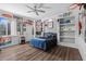 Spacious bedroom features laminate wood floors, a ceiling fan and built-in shelving with decorations at 5204 Avenue La Crosse, Lutz, FL 33558