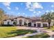 Beautiful Mediterranean-style home with a red tile roof, lush landscaping, and a circular driveway at 5204 Avenue La Crosse, Lutz, FL 33558