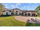 Stunning front exterior of a Mediterranean-style home with a spacious three-car garage and circular driveway at 5204 Avenue La Crosse, Lutz, FL 33558