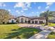 Beautiful Mediterranean-style home with a red tile roof, lush landscaping, and a circular driveway at 5204 Avenue La Crosse, Lutz, FL 33558