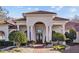Elegant front entrance of a Mediterranean-style home with brick walkway and manicured landscaping at 5204 Avenue La Crosse, Lutz, FL 33558