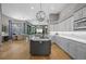 Bright kitchen features a large island with a cooktop, marble countertops, stainless appliances and herringbone wood floors at 5204 Avenue La Crosse, Lutz, FL 33558