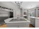 Kitchen features a large island with cooktop, stainless steel appliances, wine refrigerator, and a view to the dining room at 5204 Avenue La Crosse, Lutz, FL 33558