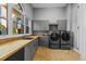 Bright laundry room with gray cabinets, butcher block countertop, sink, washer and dryer set at 5204 Avenue La Crosse, Lutz, FL 33558